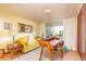 Bright living room featuring a yellow sofa, shag rug, desk area, and sliding doors to a balcony at 1090 N Lafayette St # 504, Denver, CO 80218