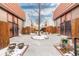 Townhouse exterior featuring a courtyard and snow-covered landscaping at 6462 E Bates Ave, Denver, CO 80222