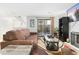 Living room with fireplace, brown couch, and sliding door to patio at 6462 E Bates Ave, Denver, CO 80222