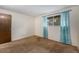 This bedroom features a window with curtains and neutral carpet at 8870 W Jewell Ave # 11, Lakewood, CO 80232