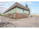 Apartment complex exterior with brick and green siding at 8870 W Jewell Ave # 11, Lakewood, CO 80232