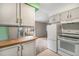 Kitchen with white appliances and cabinets, looking out to a view of the property at 8870 W Jewell Ave # 11, Lakewood, CO 80232