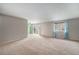 Open-concept living area with a sliding door to a balcony and view, ceiling fan, and neutral walls at 8870 W Jewell Ave # 11, Lakewood, CO 80232