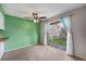 Open-concept living area with a sliding door to a balcony and view, ceiling fan, and green accent wall at 8870 W Jewell Ave # 11, Lakewood, CO 80232