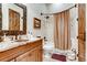Bathroom featuring a wood vanity, copper sink, shower/tub, and decorative mirror at 6963 S Espana Way, Centennial, CO 80016