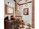 Rustic bathroom featuring a copper sink, brick accents, and elegant black-and-white checkered floors at 6963 S Espana Way, Centennial, CO 80016