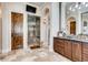 Beautiful bathroom featuring a glass shower, travertine tile, and a dark wood vanity with an elegant design at 6963 S Espana Way, Centennial, CO 80016