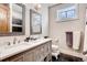 Bathroom with double sinks, gray vanity with drawers, a window, and black tile flooring at 6963 S Espana Way, Centennial, CO 80016