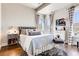 Bright bedroom features hardwood floors, corner windows with striped curtains, and a comfortable bed with stylish decor at 6963 S Espana Way, Centennial, CO 80016