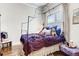 Charming bedroom with a canopy bed, adorned with a plush purple comforter, and a cozy seating area at 6963 S Espana Way, Centennial, CO 80016