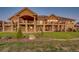 Stunning exterior of home featuring a large deck, beautiful stonework, and landscaped yard with vibrant greenery at 6963 S Espana Way, Centennial, CO 80016