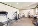 Home gym equipped with treadmill, elliptical machines, and weightlifting equipment on a rubber floor at 6963 S Espana Way, Centennial, CO 80016