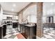 Modern kitchen featuring black countertops, stainless steel appliances, and a checkered tile floor at 6963 S Espana Way, Centennial, CO 80016
