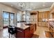 Open kitchen featuring a spacious island with granite countertops, stainless steel sink, and modern lighting at 6963 S Espana Way, Centennial, CO 80016