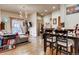 Open living room featuring hardwood floors, modern lighting, stainless steel appliances, and a cozy seating area at 6963 S Espana Way, Centennial, CO 80016