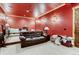 Cozy living room with red walls, a comfortable brown leather sofa, and plush carpet at 6963 S Espana Way, Centennial, CO 80016