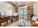 Bright office featuring built-in bookshelves, a view of the exterior, and a comfortable sitting area at 6963 S Espana Way, Centennial, CO 80016