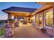 Expansive covered patio with stone pillars, outdoor fireplace, and comfortable seating area at 6963 S Espana Way, Centennial, CO 80016