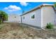 Large backyard shows siding of home, additional structure, and some yard cleanup needed at 5541 E 65Th Ave, Commerce City, CO 80022
