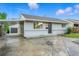 Charming exterior features tidy yard, paved driveway, carport, and inviting entryway at 5541 E 65Th Ave, Commerce City, CO 80022