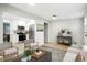 Bright living room with light hardwood floors, modern furniture, and an open-concept kitchen at 5541 E 65Th Ave, Commerce City, CO 80022