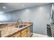 Close-up shot of stainless steel sink, granite countertops, and wooden cabinets at 1125 N Washington St # 303, Denver, CO 80203