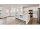 Open concept kitchen with stainless steel appliances, a center island, and sleek white cabinetry at 2090 S Haleyville Way, Aurora, CO 80018