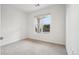 A bright bedroom offers a large window that provides natural light and neutral carpet at 19019 E Warren Dr # H104, Aurora, CO 80013