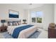 Staged bedroom featuring a large bed, lamps, and a large bright window at 19019 E Warren Dr # H104, Aurora, CO 80013