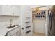 A well-organized pantry with shelving, complemented by a sleek sink, and kitchen appliances at 19019 E Warren Dr # H104, Aurora, CO 80013