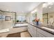 Bright bathroom with double sink vanity, soaking tub, and glass-enclosed shower at 28454 Meadow Dr, Evergreen, CO 80439