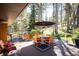 Inviting deck area features an outdoor dining set, grill, and cozy seating, surrounded by a tranquil forest setting at 28454 Meadow Dr, Evergreen, CO 80439
