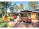 Spacious outdoor deck features a dining area, lounge chairs, and lush greenery, creating a relaxing and inviting space at 28454 Meadow Dr, Evergreen, CO 80439