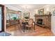 Cozy dining room boasts natural light, a stone fireplace, and a chandelier, creating an inviting atmosphere at 28454 Meadow Dr, Evergreen, CO 80439
