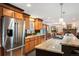 Open kitchen with stainless steel appliances, granite counters, adjacent to a dining room with a stone fireplace at 28454 Meadow Dr, Evergreen, CO 80439