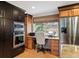 Charming kitchen features dark cabinets, stainless appliances, and a built-in desk area with backyard views at 28454 Meadow Dr, Evergreen, CO 80439