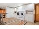 Functional laundry room with modern washer and dryer, ample storage, and stylish rug at 28454 Meadow Dr, Evergreen, CO 80439