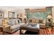 Inviting living room featuring comfortable seating, area rug, and natural light from a large window at 28454 Meadow Dr, Evergreen, CO 80439