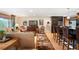 Cozy living room open to kitchen, featuring hardwood floors, comfortable seating, and a large television at 28454 Meadow Dr, Evergreen, CO 80439