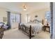 Spacious main bedroom featuring a king-size bed, large windows, neutral carpet, and a ceiling fan at 3242 S Jebel Way, Aurora, CO 80013