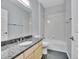 Well-lit bathroom features a combination tub and shower, neutral paint, and granite countertop at 4501 S Tabor Ct, Morrison, CO 80465