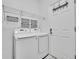 Bright laundry room features side-by-side washer and dryer, wire shelving, and tile floors at 4501 S Tabor Ct, Morrison, CO 80465