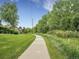 Scenic paved path surrounded by trees, green grass, and native plants at 4501 S Tabor Ct, Morrison, CO 80465