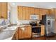 Bright kitchen with stainless steel appliances, light wood cabinets and generous counter space at 9519 Devon Ct, Highlands Ranch, CO 80126