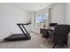 Bright bedroom featuring a treadmill, a desk with a computer, and a large window with views of the neighborhood at 131 S Vandriver Way, Aurora, CO 80018