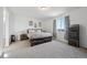 Bright, spacious bedroom with soft carpeting, a large window, and stylish rustic wood furnishings at 131 S Vandriver Way, Aurora, CO 80018