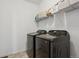 Convenient laundry area with modern black appliances and ample shelving for storage solutions at 131 S Vandriver Way, Aurora, CO 80018