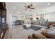 Open-concept living area featuring a large sectional sofa, a dining table, and a view into the kitchen at 131 S Vandriver Way, Aurora, CO 80018