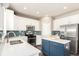Kitchen with stainless appliances, white cabinets, island and blue glass subway tile backsplash at 2881 Black Canyon Way, Castle Rock, CO 80109