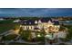 Expansive estate with sprawling lawn, pool, and elegant stone architecture, lit up against a night sky at 15355 Zuni St, Broomfield, CO 80023